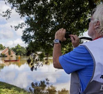 James Hennessy, a Red Cross mental health volunteer from Tallahassee, Florida, takes a photo of Old Jefferson Highway which he was hoping to cross to reach Baton Rouge in Prairieville, La., Tuesday, Aug. 16, 2016. (AP Photo/Max Becherer)